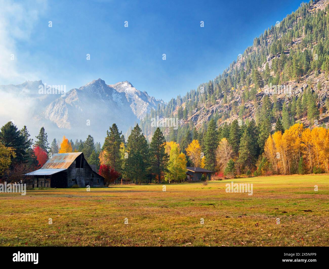 USA, Bundesstaat Washington, Chelan County. Scheune und Ranch mit den Enchantments im Hintergrund im Herbst. (Nur Für Redaktionelle Zwecke) Stockfoto