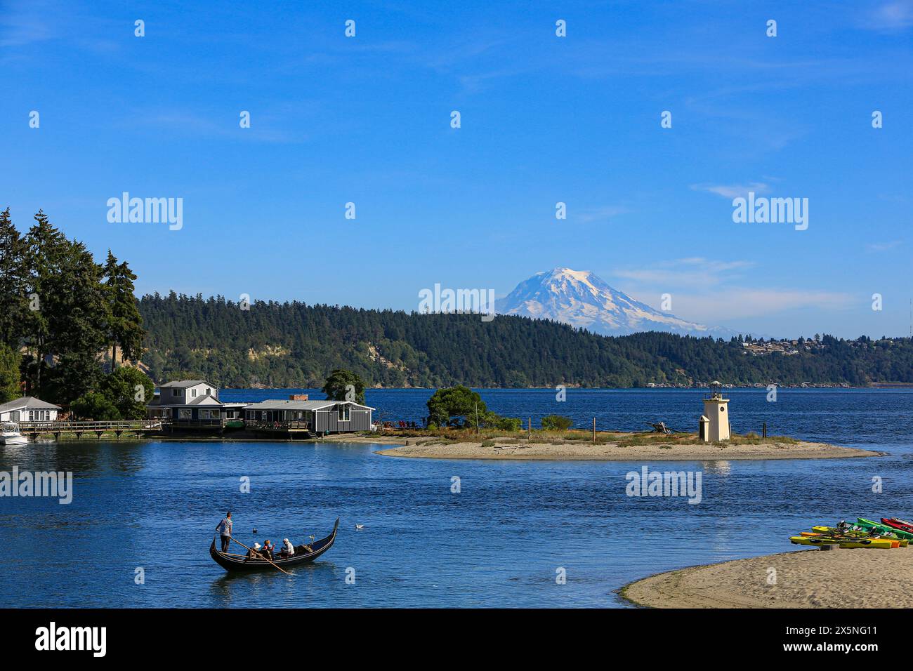 Gig Harbor, Bundesstaat Washington, USA. Mount Rainier Gipfel über Gig Harbor, während Touristen in einer Gondelfahrt auf dem Wasser fahren. (Nur Für Redaktionelle Zwecke) Stockfoto