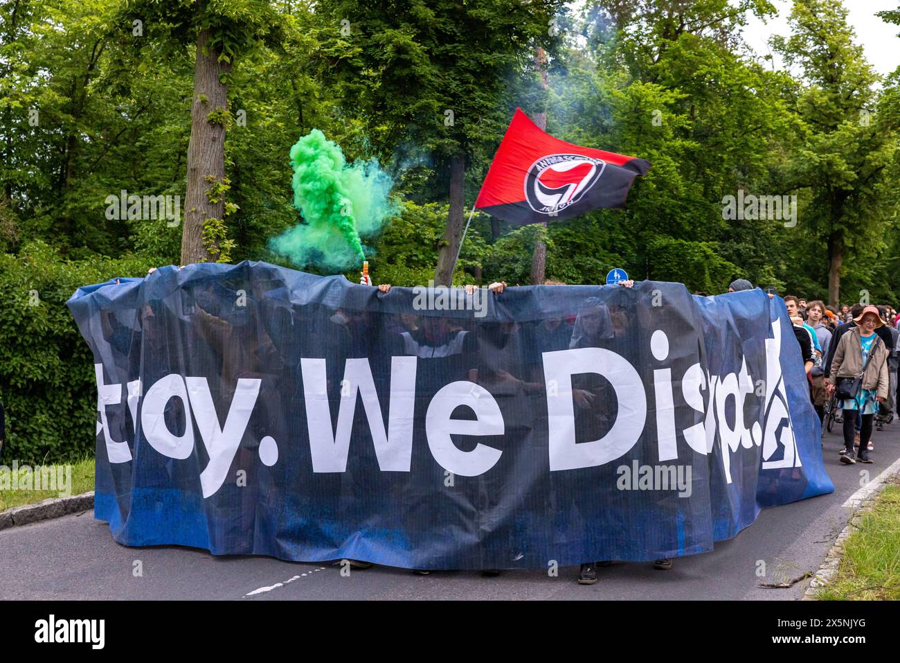 Camp der Disrupt-now in Grüneheide gegen Tesla Deutschland, Grünheide am 10.05.2024: Junge Menschen sind mit grüner Rauch und Antifa Fahnen und einem Banner We distroy. Wir stören. Zurück zum Basis Camp gegangen. *** Camp of Disrupt jetzt in Grüneheide gegen Tesla Deutschland, Grünheide am 10 05 2024 gingen Jugendliche mit grünem Rauch und antifa-Fahnen und einem Banner zurück ins Basislager Stockfoto