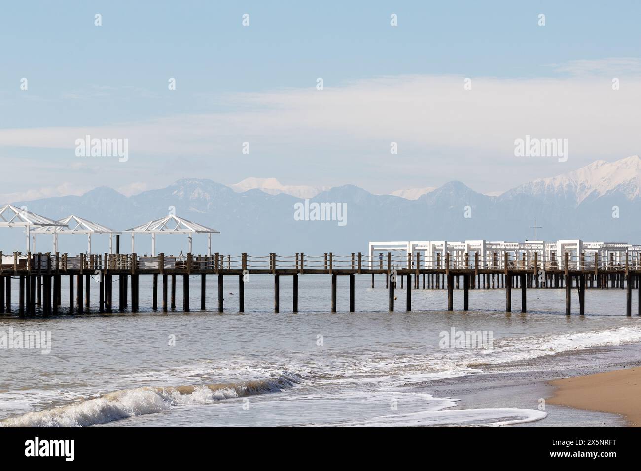 Uferdamm in der Türkei. Schneebedeckte Berggipfel am Horizont im Dunst Stockfoto