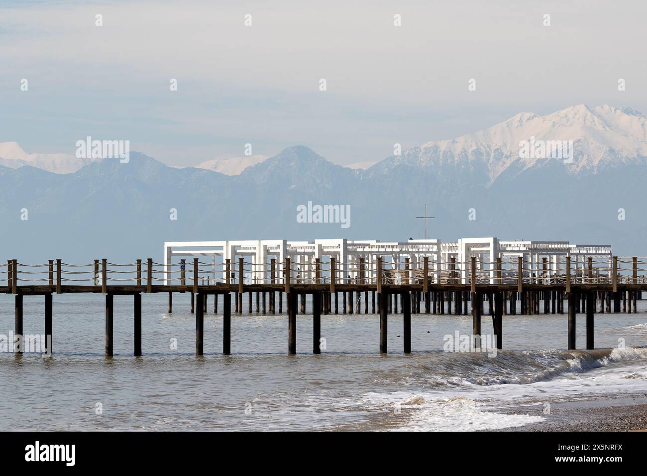 Uferdamm in der Türkei. Schneebedeckte Berggipfel am Horizont im Dunst Stockfoto