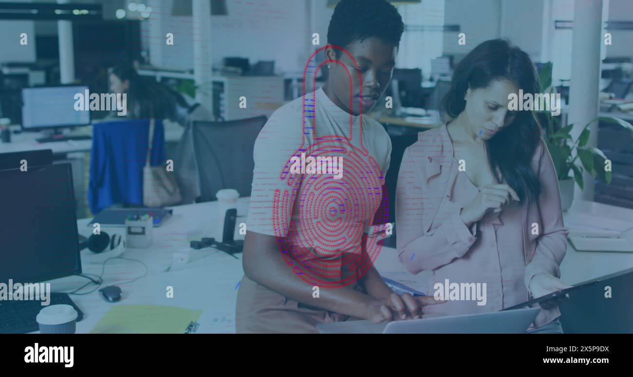 Ein vielfältiges Team arbeitet zusammen und betrachtet Notebooks Stockfoto