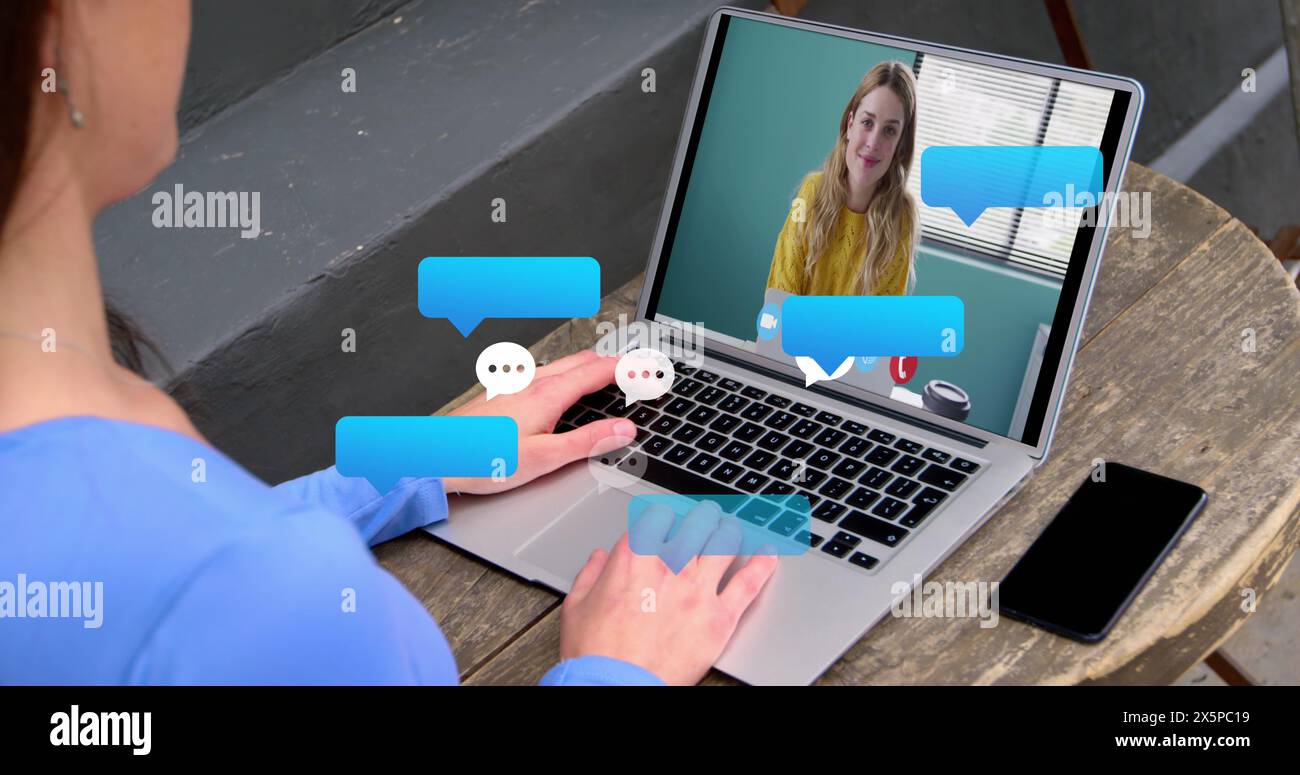 Bild einer fallenden Nachrichtenblase über kaukasischen Frauen mit Laptop Stockfoto