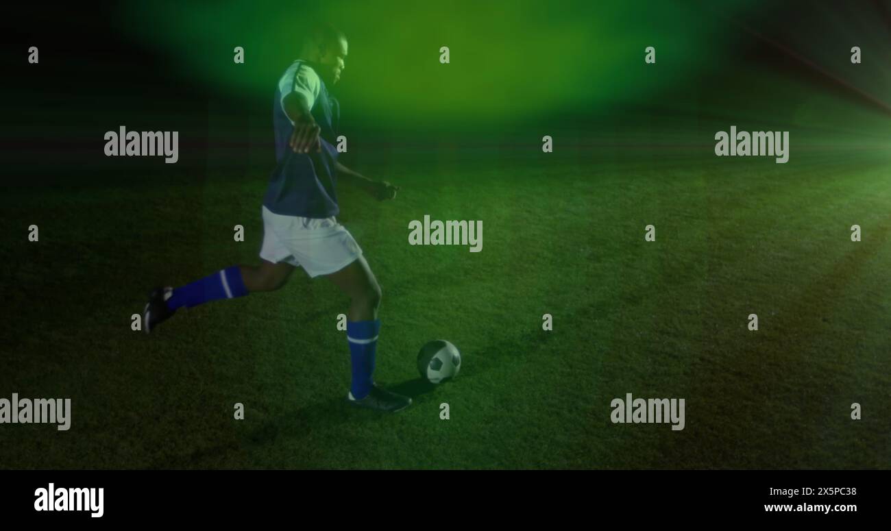 Bild eines grünen Lichtflecks gegen afroamerikanischen Fußballspieler, der den Ball tritt Stockfoto