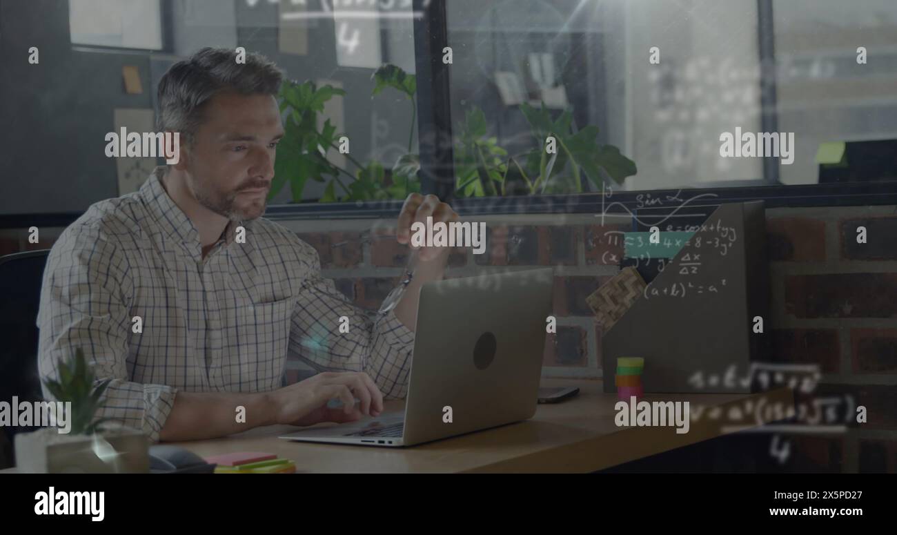 Bild mathematischer Gleichungen über kaukasische Geschäftsleute, die im Büro am Laptop arbeiten Stockfoto