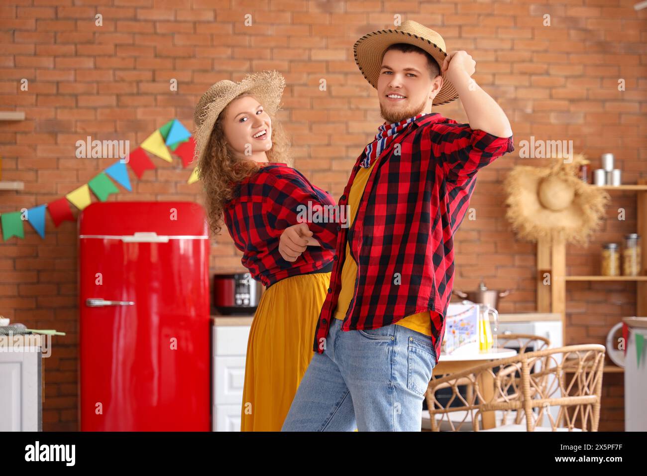 Glückliches junges Paar, das zu Hause tanzt. Festa Junina Feier Stockfoto