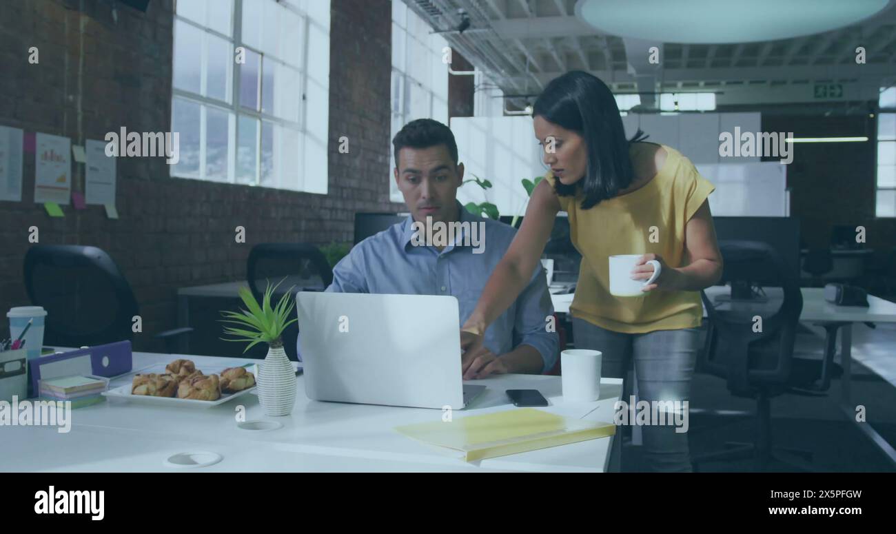 Kaukasischer Mann und birassische Frau arbeiten im Büro am Computer Stockfoto