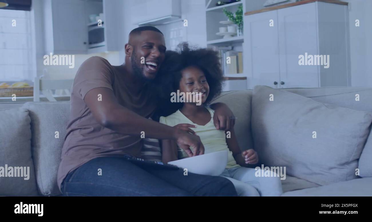 Afroamerikanischer Mann und Kind lachen, genießen Fernsehen auf blauem Hintergrund Stockfoto