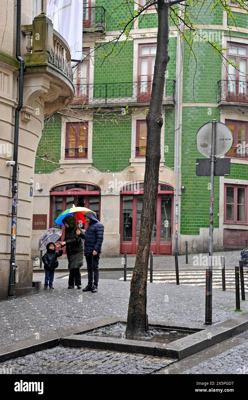 Familie mit Sonnenschirmen an regnerischen Tagen in Porto, Portugal, Europa Stockfoto