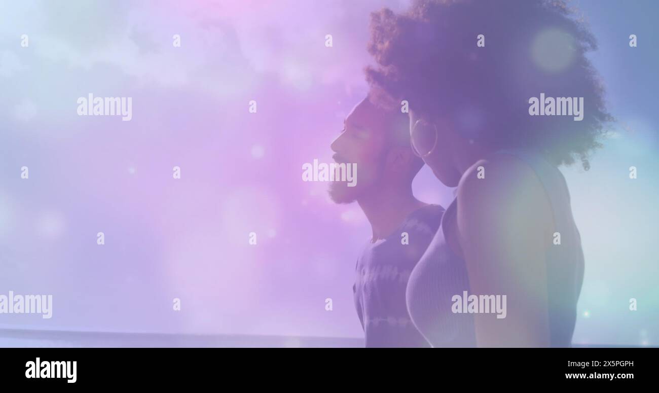 Bild von Lichtflecken gegen afroamerikanische Paare, die zusammen am Strand spazieren Stockfoto