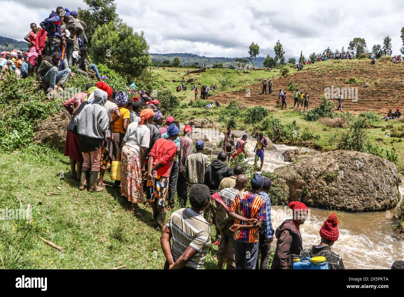 Nakuru, Kenia. Mai 2024. Mitglieder der Gemeinde beobachten, wie einheimische Taucher nach Leichen von zwei jungen Schwestern suchen, die ertrunken sind, als sie versuchten, einen geschwollenen Njoro River in Ketiro Village, Nakuru County, zu überqueren. Ihr tragischer Tod erhöht die Zahl von mindestens 230 Menschen, die nach starken Regenfällen, die in Kenia zu großen Überschwemmungen geführt haben, ihr Leben verloren haben. Quelle: SOPA Images Limited/Alamy Live News Stockfoto