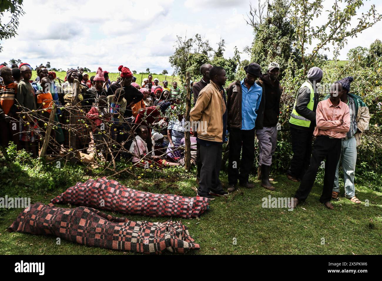 Nakuru, Kenia. Mai 2024. (ANMERKUNG DER REDAKTION: Bild zeigt den Tod) Mitglieder der Gemeinde stehen hinter den Leichen der beiden jungen Schwestern, die ertrunken sind, als sie versuchten, den geschwollenen Njoro River im Dorf Ketiro im County Nakuru zu überqueren. Ihr tragischer Tod erhöht die Zahl von mindestens 230 Menschen, die nach starken Regenfällen, die in Kenia zu großen Überschwemmungen geführt haben, ihr Leben verloren haben. Quelle: SOPA Images Limited/Alamy Live News Stockfoto