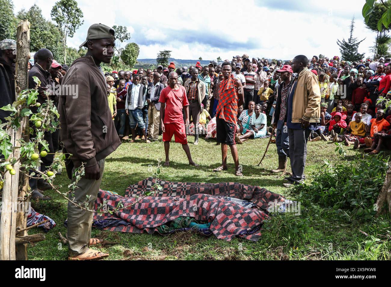 Nakuru, Kenia. Mai 2024. (ANMERKUNG DER REDAKTION: Bild zeigt den Tod) Mitglieder der Gemeinde stehen hinter den Leichen der beiden jungen Schwestern, die ertrunken sind, als sie versuchten, den geschwollenen Njoro River im Dorf Ketiro im County Nakuru zu überqueren. Ihr tragischer Tod erhöht die Zahl von mindestens 230 Menschen, die nach starken Regenfällen, die in Kenia zu großen Überschwemmungen geführt haben, ihr Leben verloren haben. Quelle: SOPA Images Limited/Alamy Live News Stockfoto