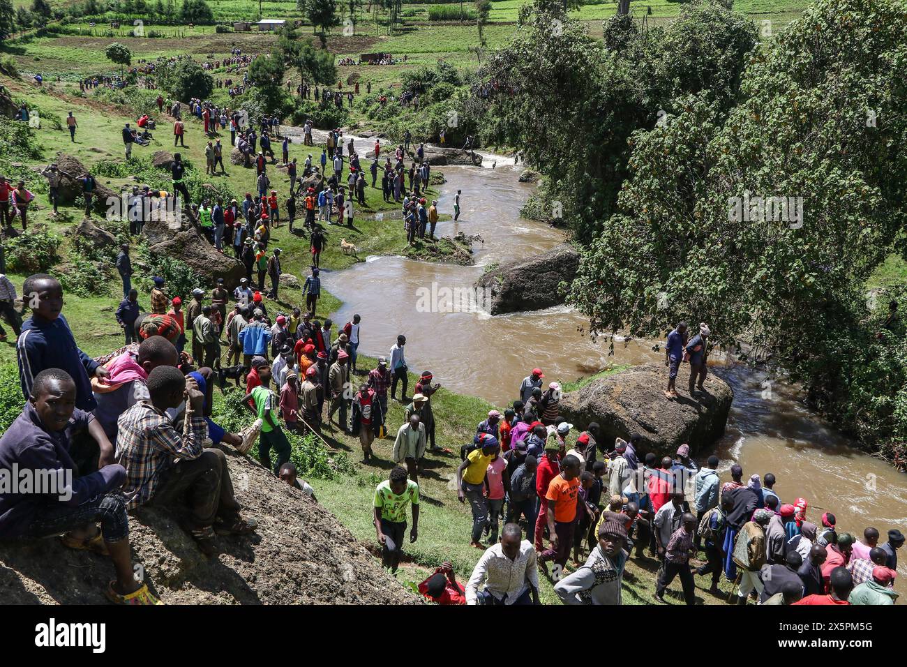 Nakuru, Kenia. Mai 2024. Mitglieder der Gemeinde beobachten, wie einheimische Taucher nach Leichen von zwei jungen Schwestern suchen, die ertrunken sind, als sie versuchten, einen geschwollenen Njoro River in Ketiro Village, Nakuru County, zu überqueren. Ihr tragischer Tod erhöht die Zahl von mindestens 230 Menschen, die nach starken Regenfällen, die in Kenia zu großen Überschwemmungen geführt haben, ihr Leben verloren haben. (Foto: James Wakibia/SOPA Images/SIPA USA) Credit: SIPA USA/Alamy Live News Stockfoto