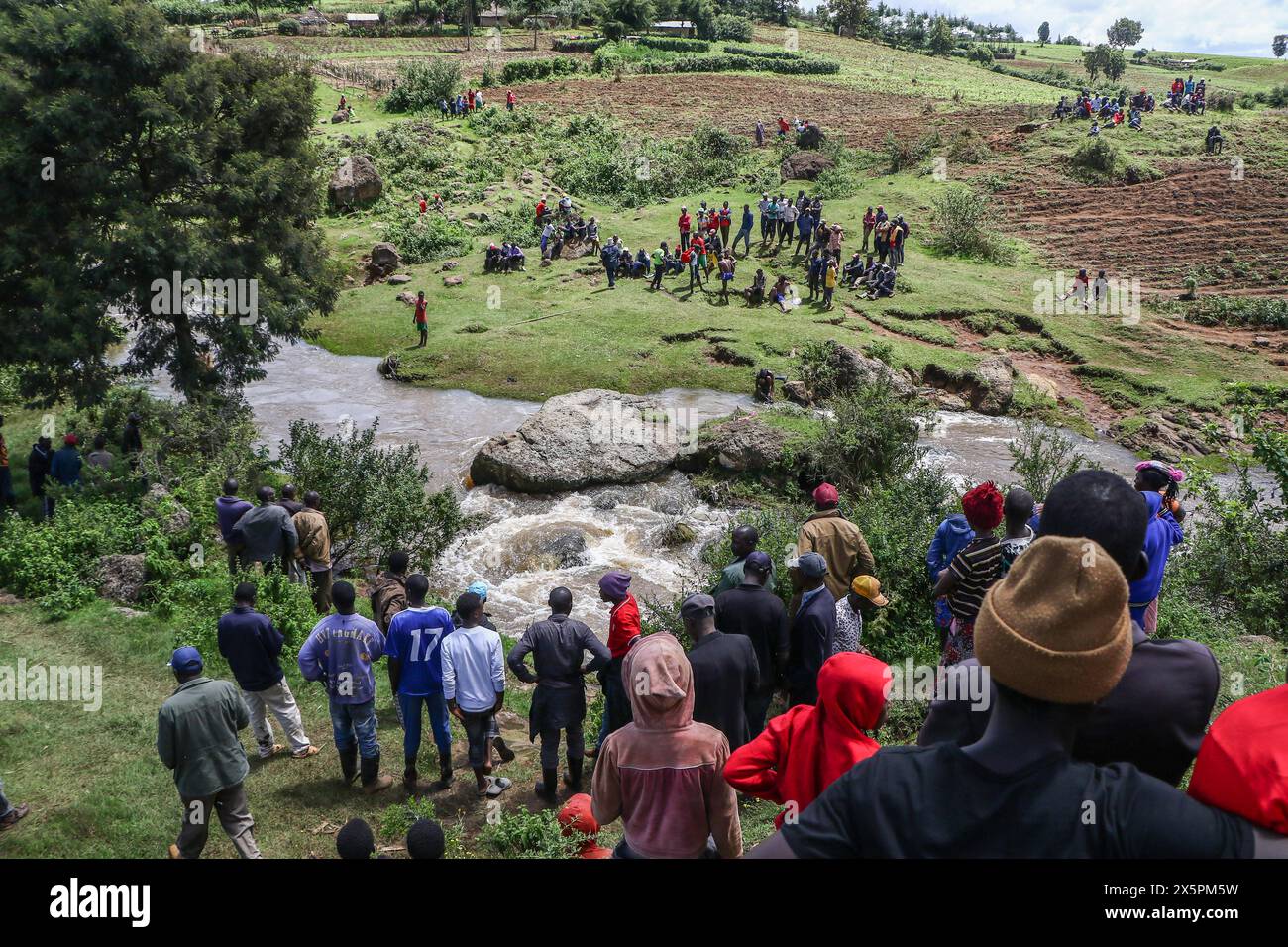 Nakuru, Kenia. Mai 2024. Mitglieder der Gemeinde beobachten, wie einheimische Taucher nach Leichen von zwei jungen Schwestern suchen, die ertrunken sind, als sie versuchten, einen geschwollenen Njoro River in Ketiro Village, Nakuru County, zu überqueren. Ihr tragischer Tod erhöht die Zahl von mindestens 230 Menschen, die nach starken Regenfällen, die in Kenia zu großen Überschwemmungen geführt haben, ihr Leben verloren haben. (Foto: James Wakibia/SOPA Images/SIPA USA) Credit: SIPA USA/Alamy Live News Stockfoto