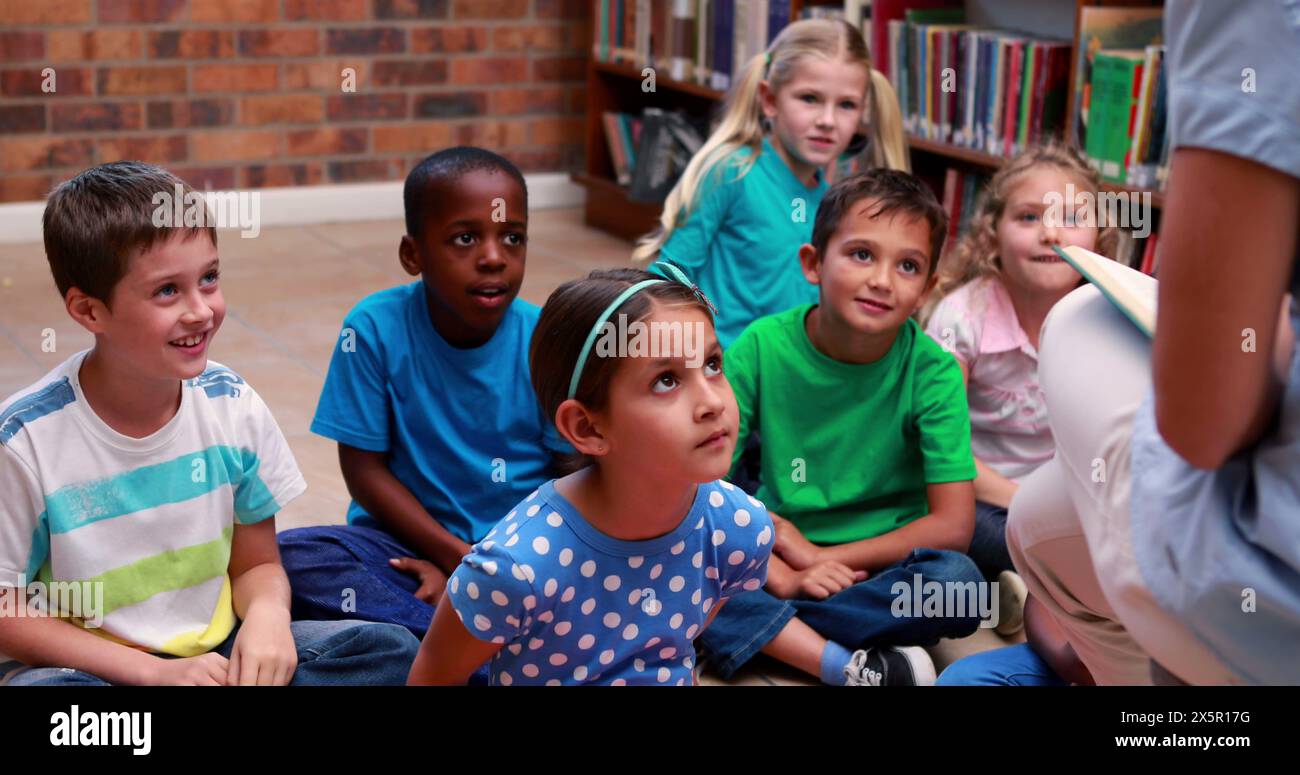 Verschiedene Schüler in bunten Hemden hören einem Lehrer in der Schule zu Stockfoto