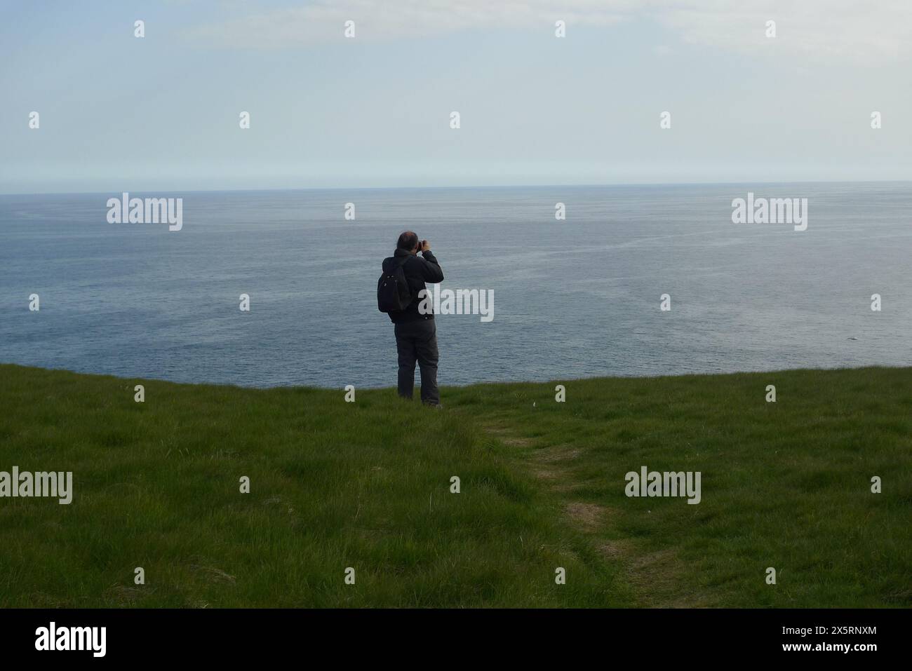 Ein erwachsener, männlicher Fotograf, 40er Jahre, kaukasier am Storhofdi Lookout am südlichsten Ende von Heimaey, Westman Island, Island Stockfoto