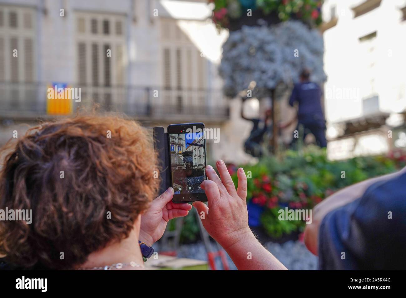 Touristen machen ein Foto mit einem Telefon in Temps de Flors in Katalonien. Flower Time Festival Stockfoto