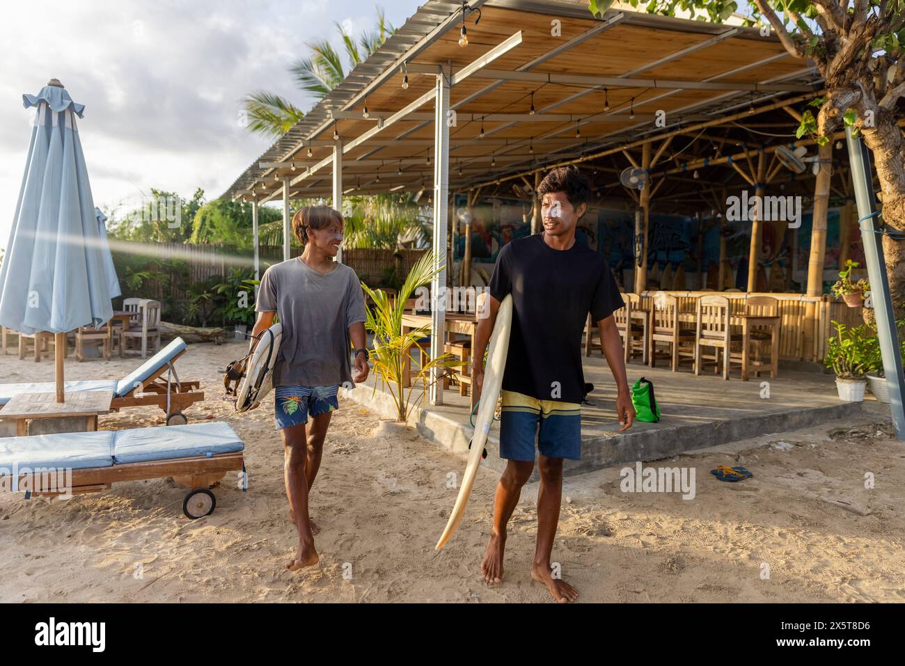 Surfer gehen mit Surfbrettern am Strand Stockfoto