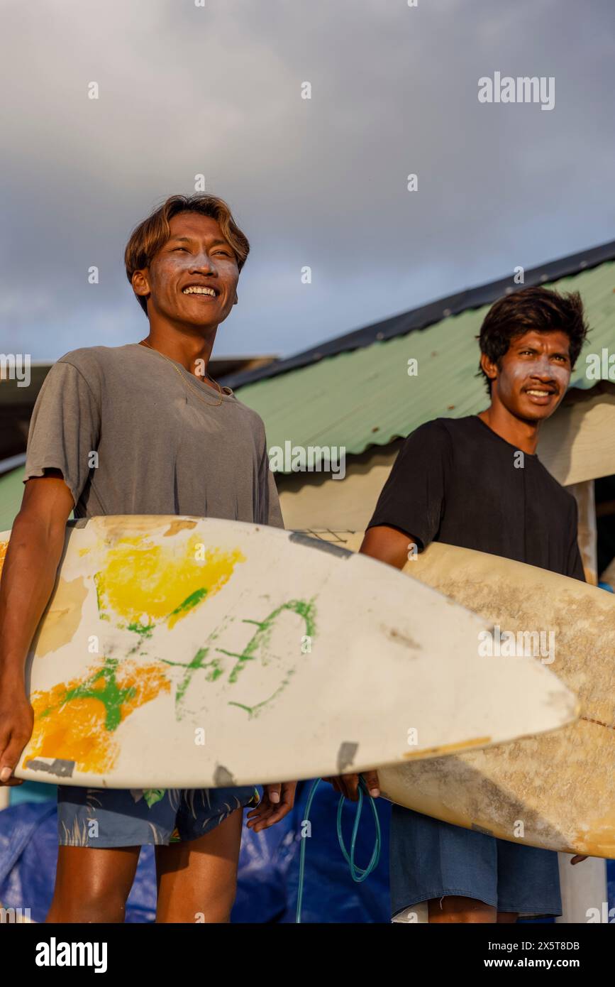 Lächelnde Surfer stehen mit Surfbrettern Stockfoto