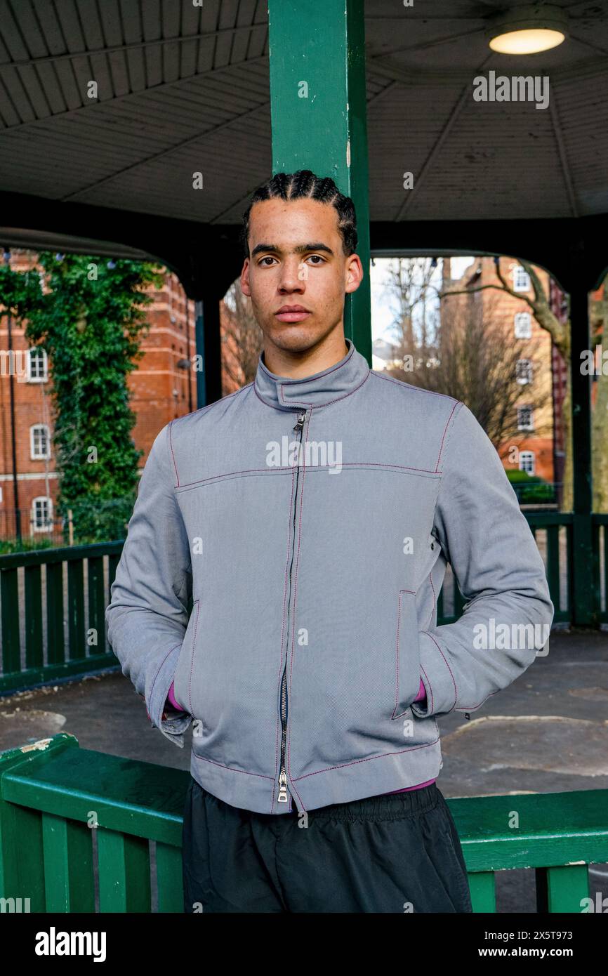 Porträt eines jungen Mannes, der draußen mit Händen in Taschen steht Stockfoto