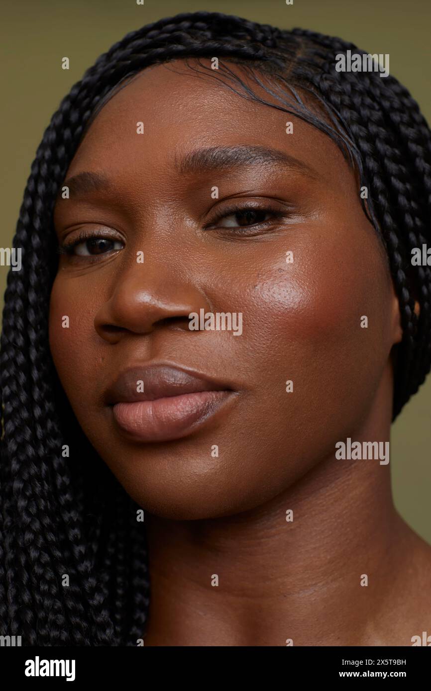 Porträt einer ernsten Frau vor grünem Hintergrund Stockfoto