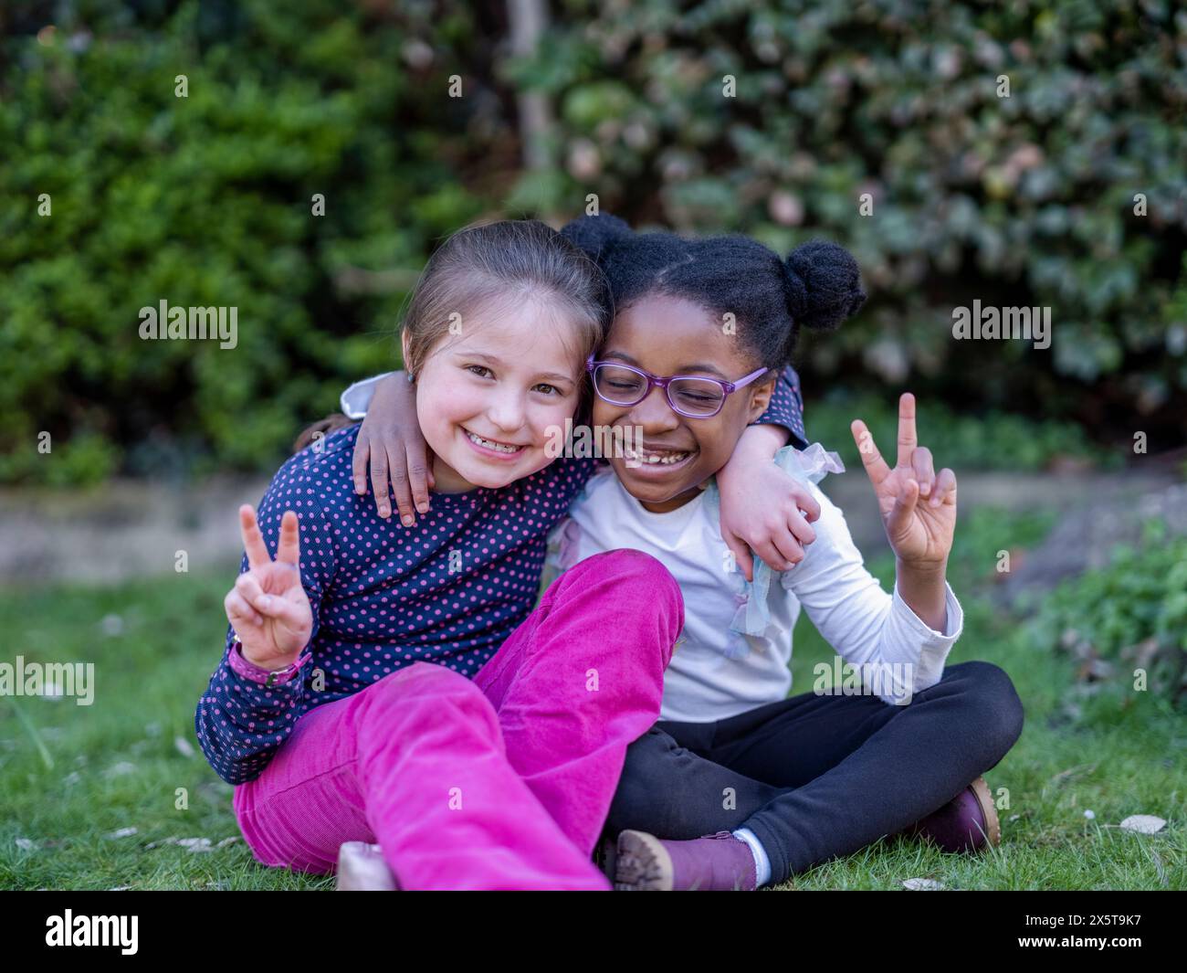 Porträt von Freundinnen (6-7), die Friedenszeichen machen Stockfoto