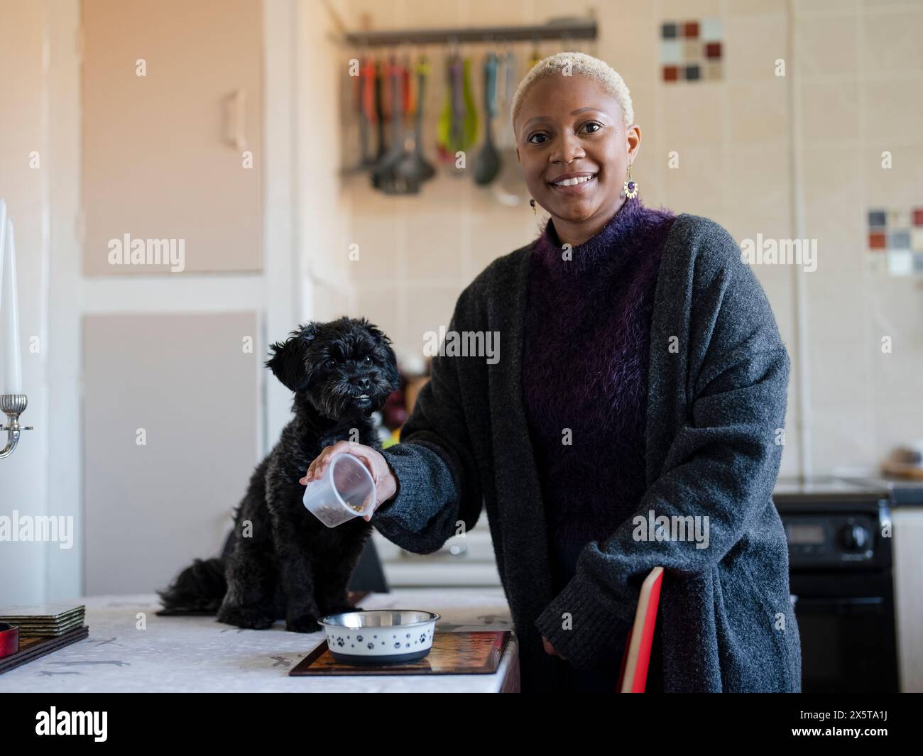 Porträt einer Frau, die Hundefutter in eine Schüssel im Speisesaal gießt Stockfoto