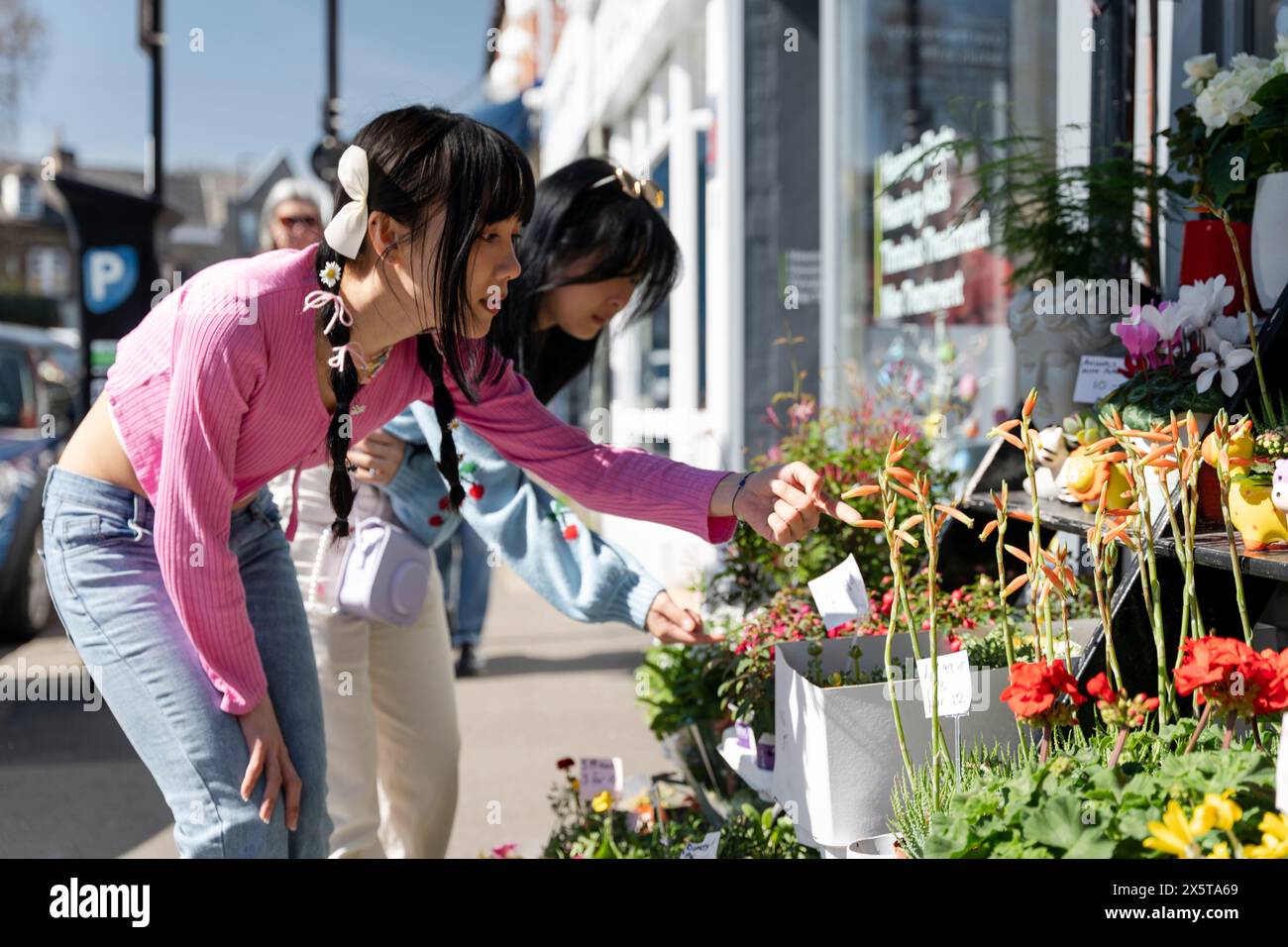 Junge Freundinnen, die Blumen kaufen Stockfoto