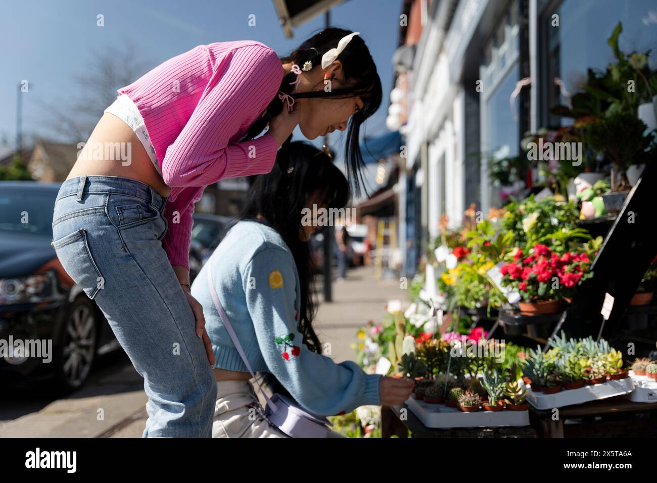 Junge Freundinnen, die Blumen kaufen Stockfoto