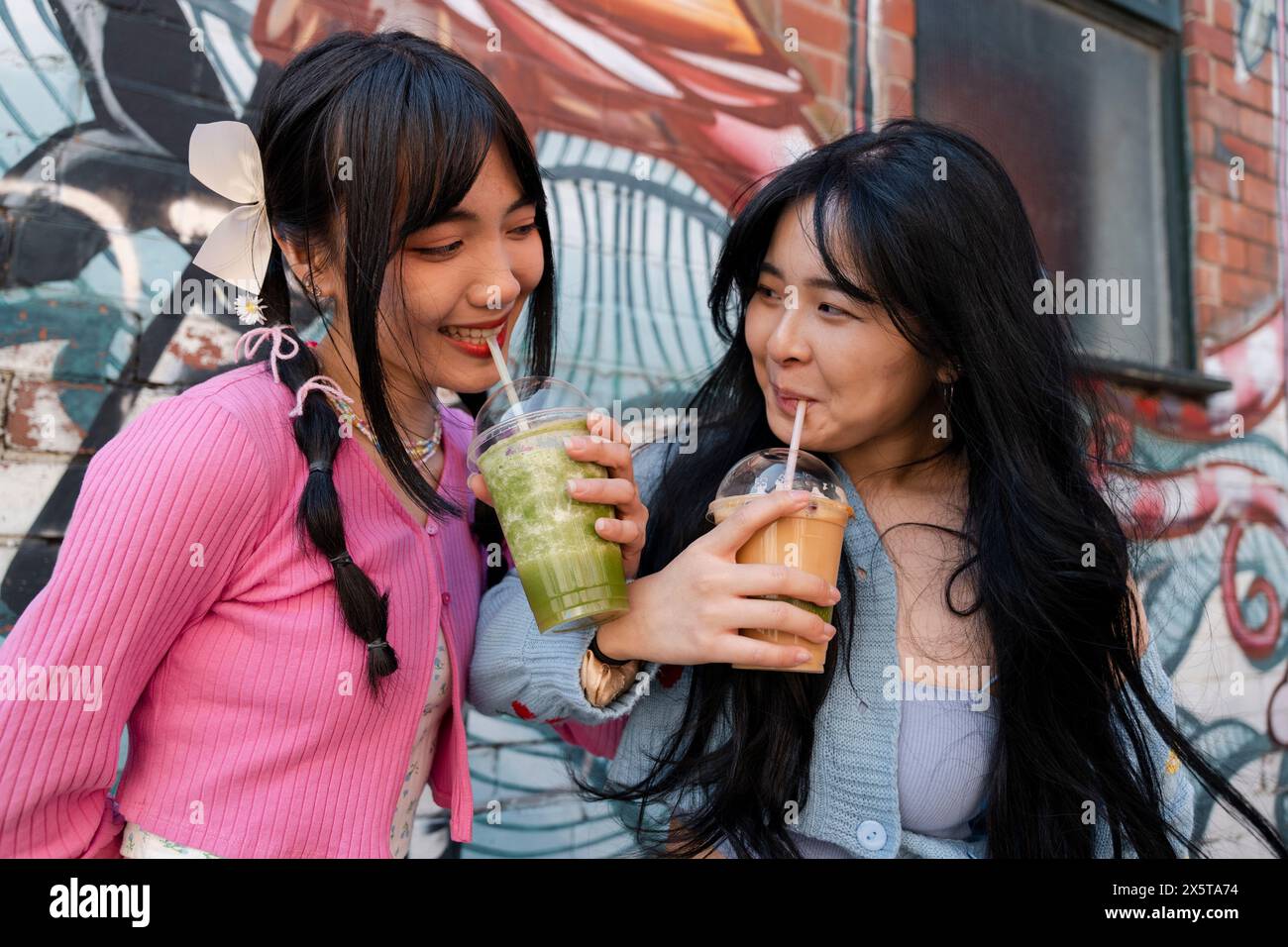 Junge Frauen trinken süße Getränke Stockfoto