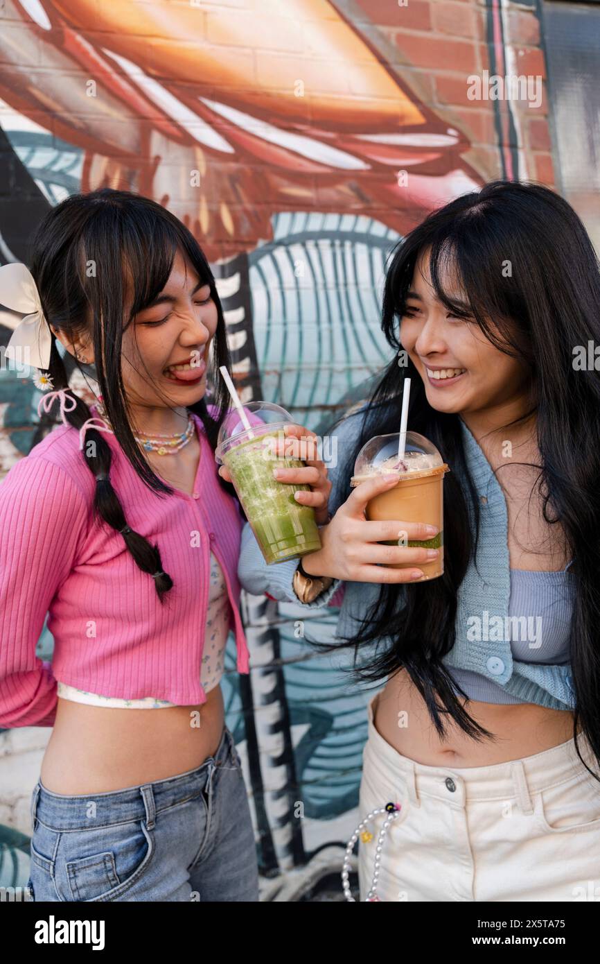 Junge Frauen trinken süße Getränke Stockfoto