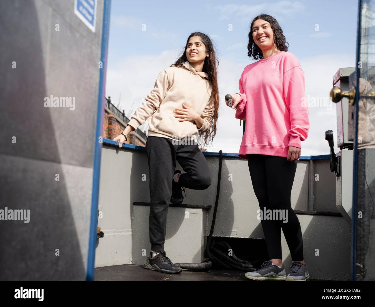 Zwei lächelnde Freundinnen am Heck des Bootes Stockfoto