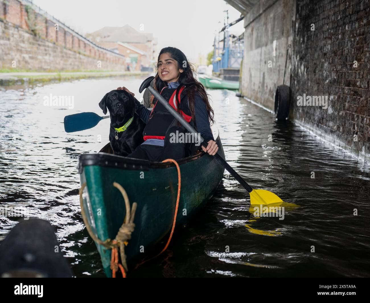 Junge Frau und Hund im Kanu Stockfoto