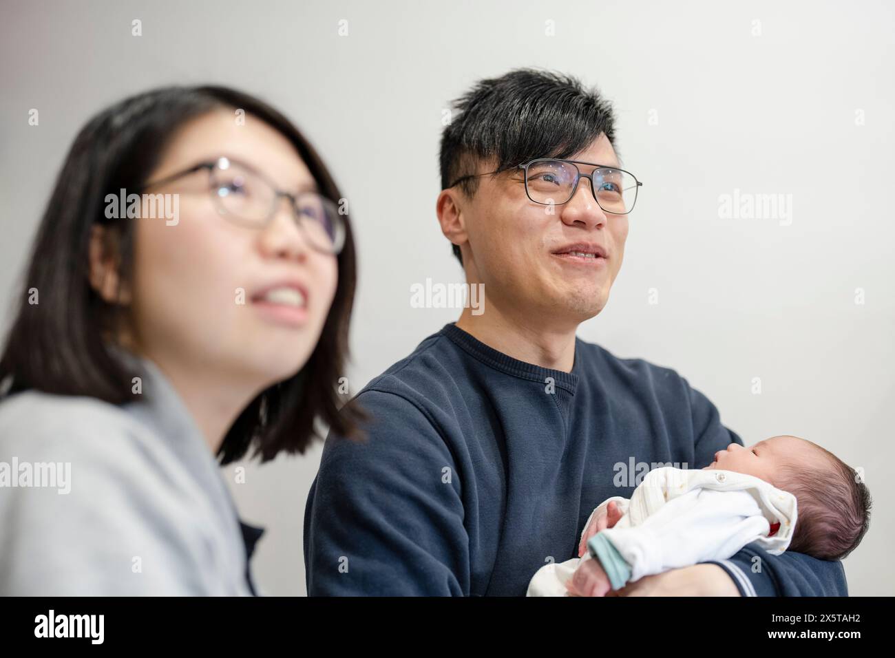 Zwei Eltern mit Baby-Tochter (1-0 Monate) zu Hause Stockfoto