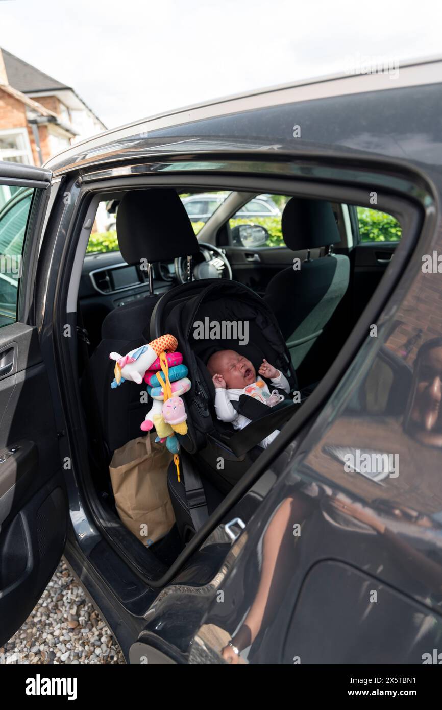 Baby-Mädchen, das auf einem Autositz sitzt Stockfoto
