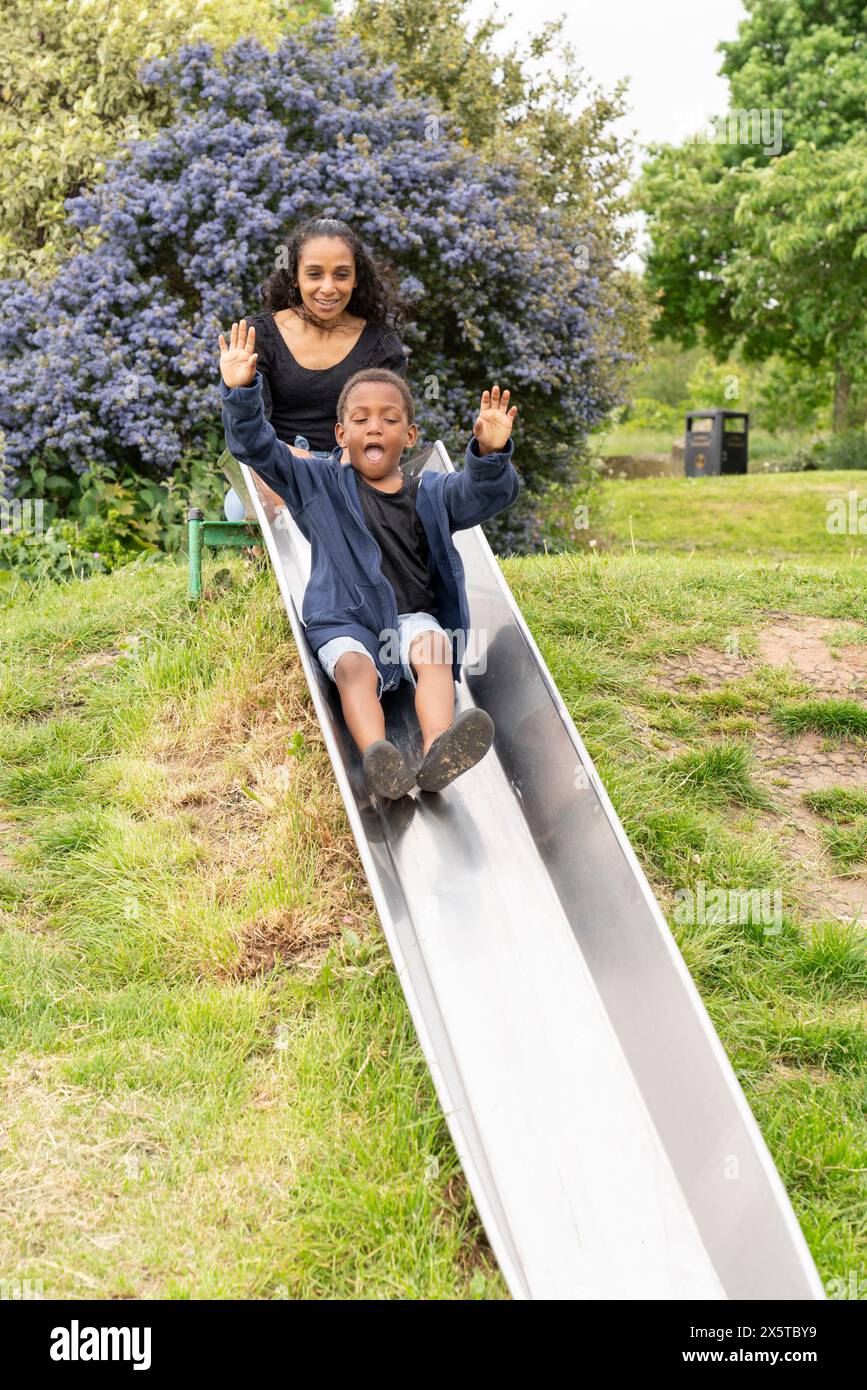 Mutter und Sohn haben Spaß auf der Rutsche auf dem Spielplatz Stockfoto