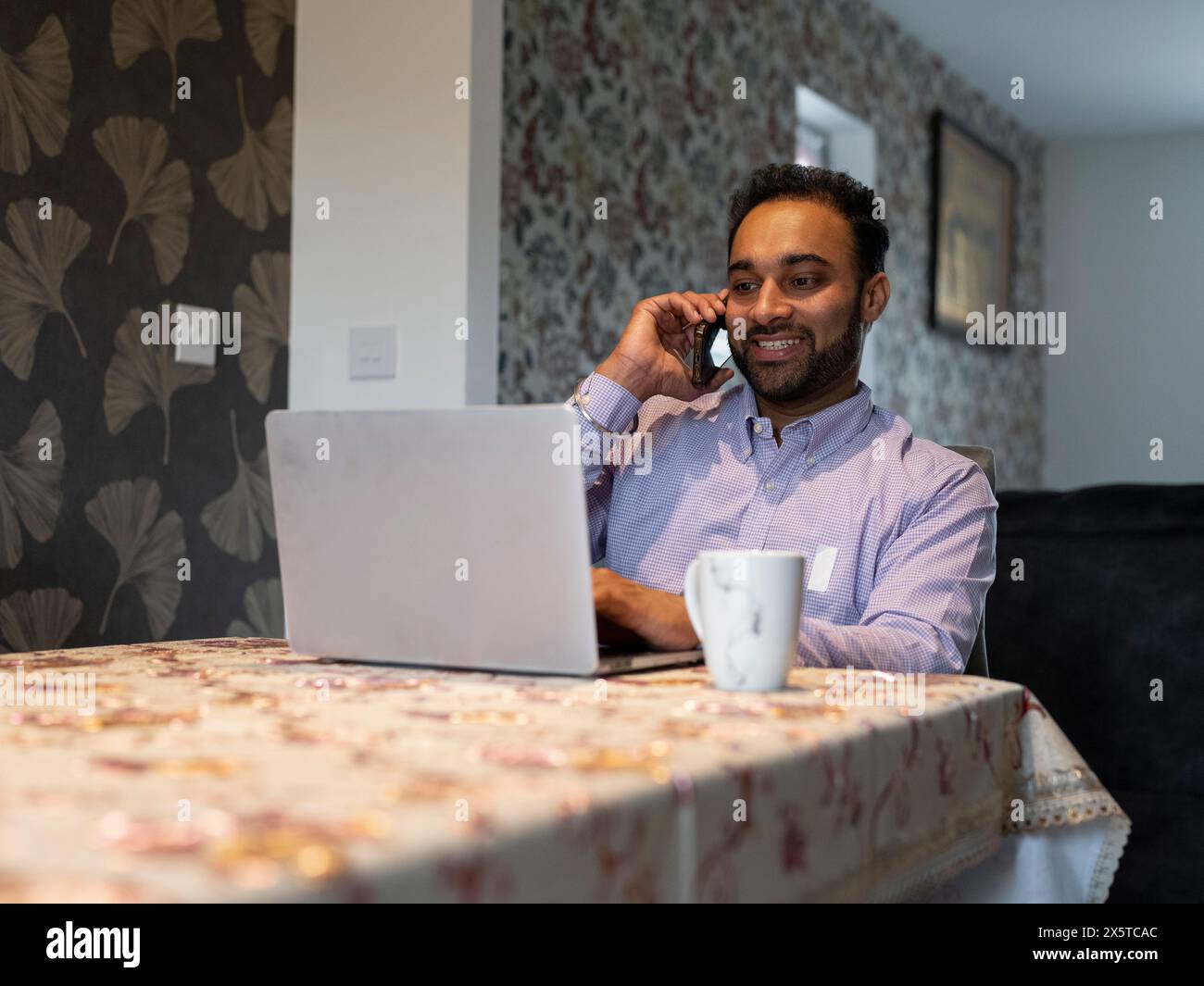 Mann, der von zu Hause aus am Laptop arbeitet Stockfoto