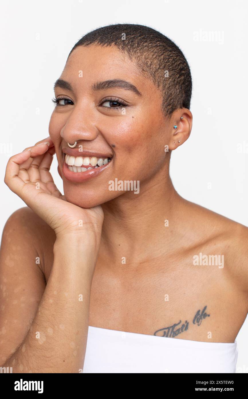 Studio-Porträt einer lächelnden Frau mit kurzen Haaren und Nasenring Stockfoto