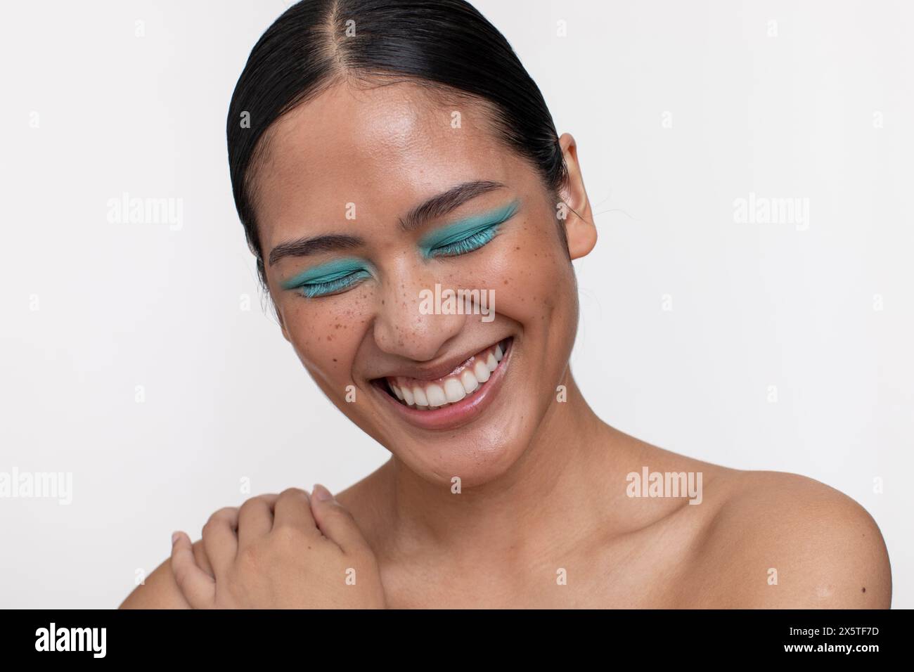 Porträt einer lächelnden Frau mit blauem Make-up Stockfoto