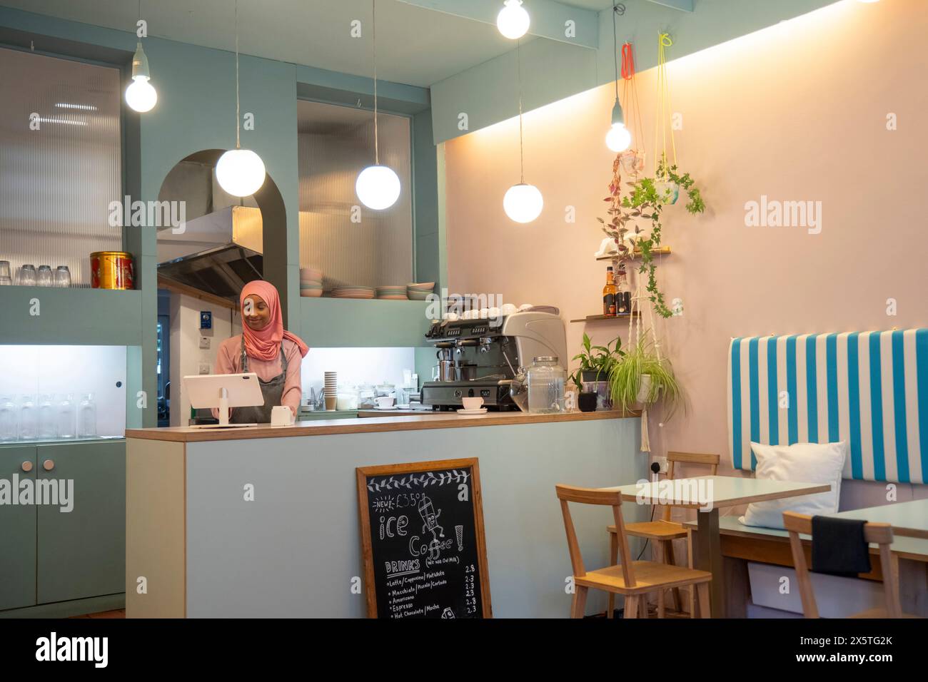 Junge Frau im Hijab, die im Café arbeitet Stockfoto