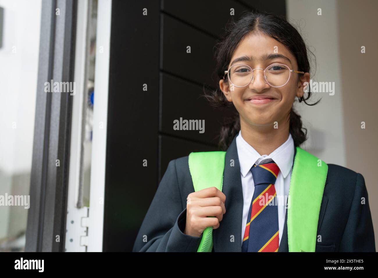 Das Schulmädchen verlässt das Haus zur Schule Stockfoto