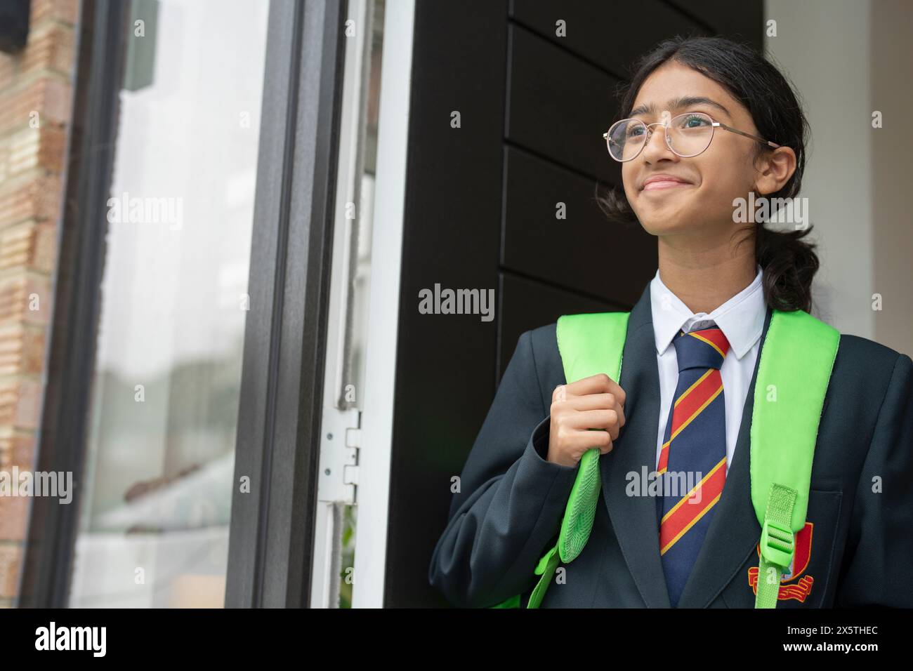 Das Schulmädchen verlässt das Haus zur Schule Stockfoto