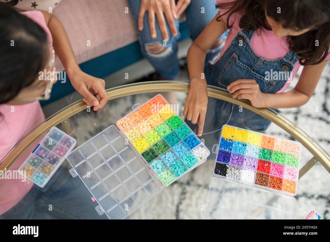 Schwestern spielen mit Perlen im Wohnzimmer Stockfoto