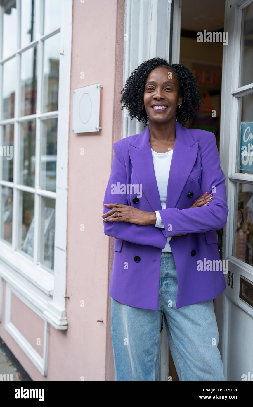 Porträt einer Geschäftsinhaberin, die vor einem offenen Laden steht Stockfoto