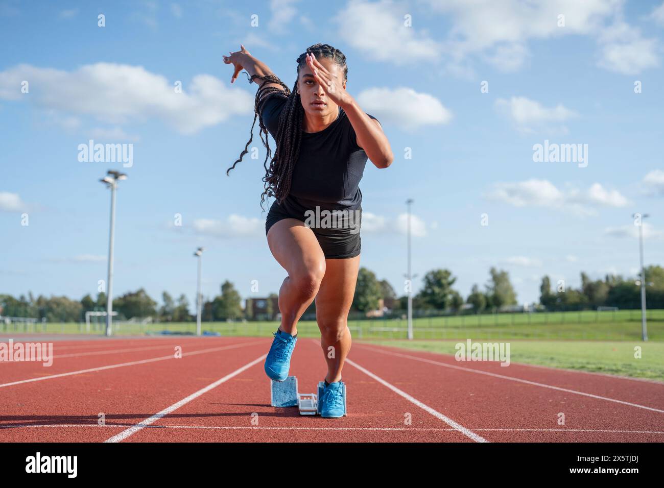 Weibliche Athletin sprintet aus der Startlinie im Stadion Stockfoto