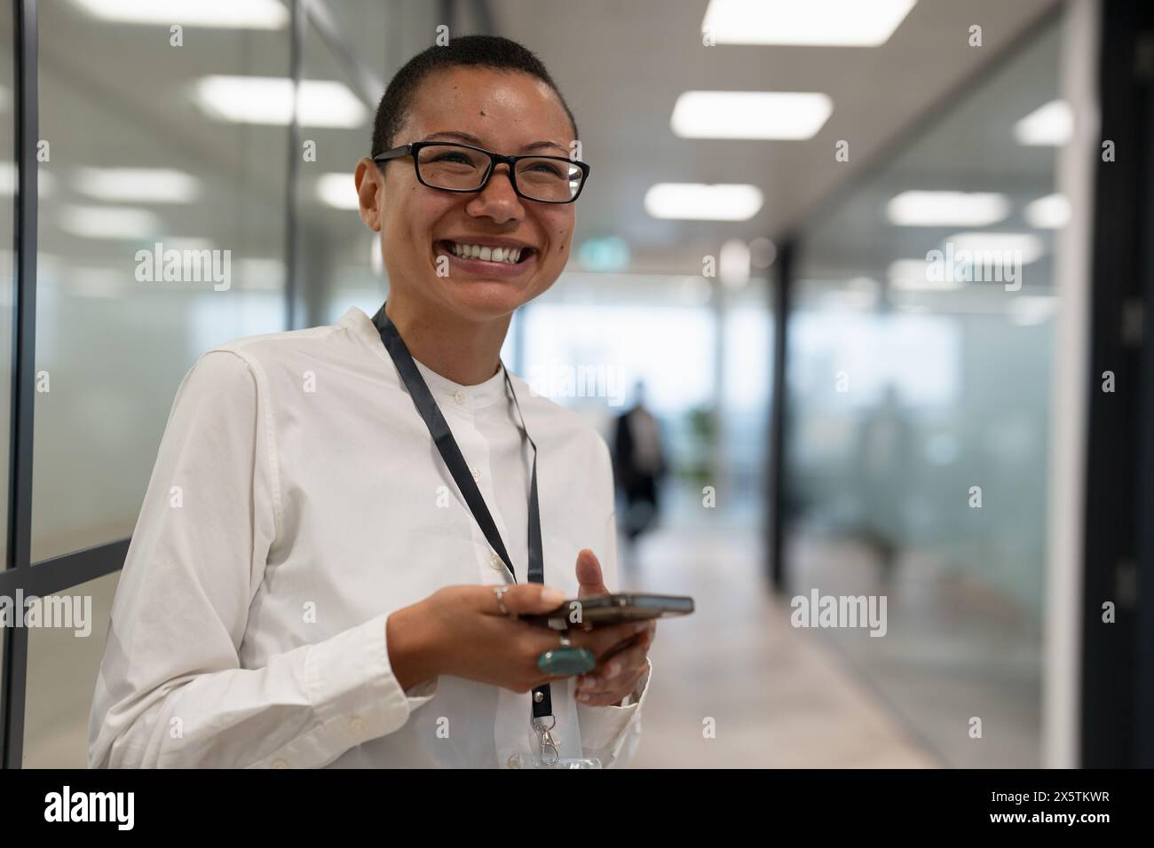 Nicht binärer Büroangestellter, der auf dem Flur steht Stockfoto