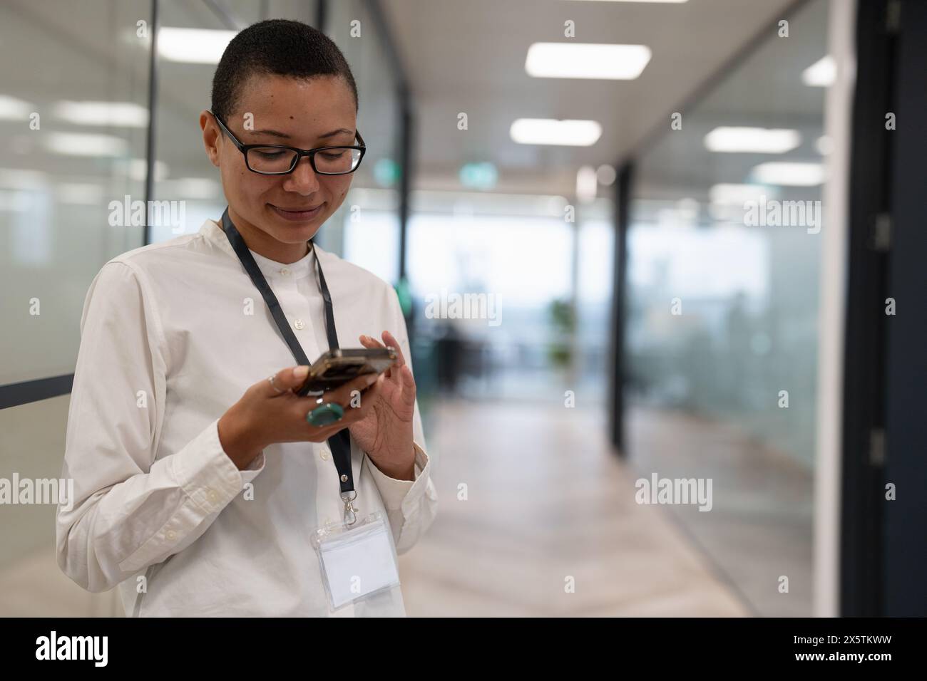Nicht binärer Büroangestellter, der auf dem Flur steht Stockfoto