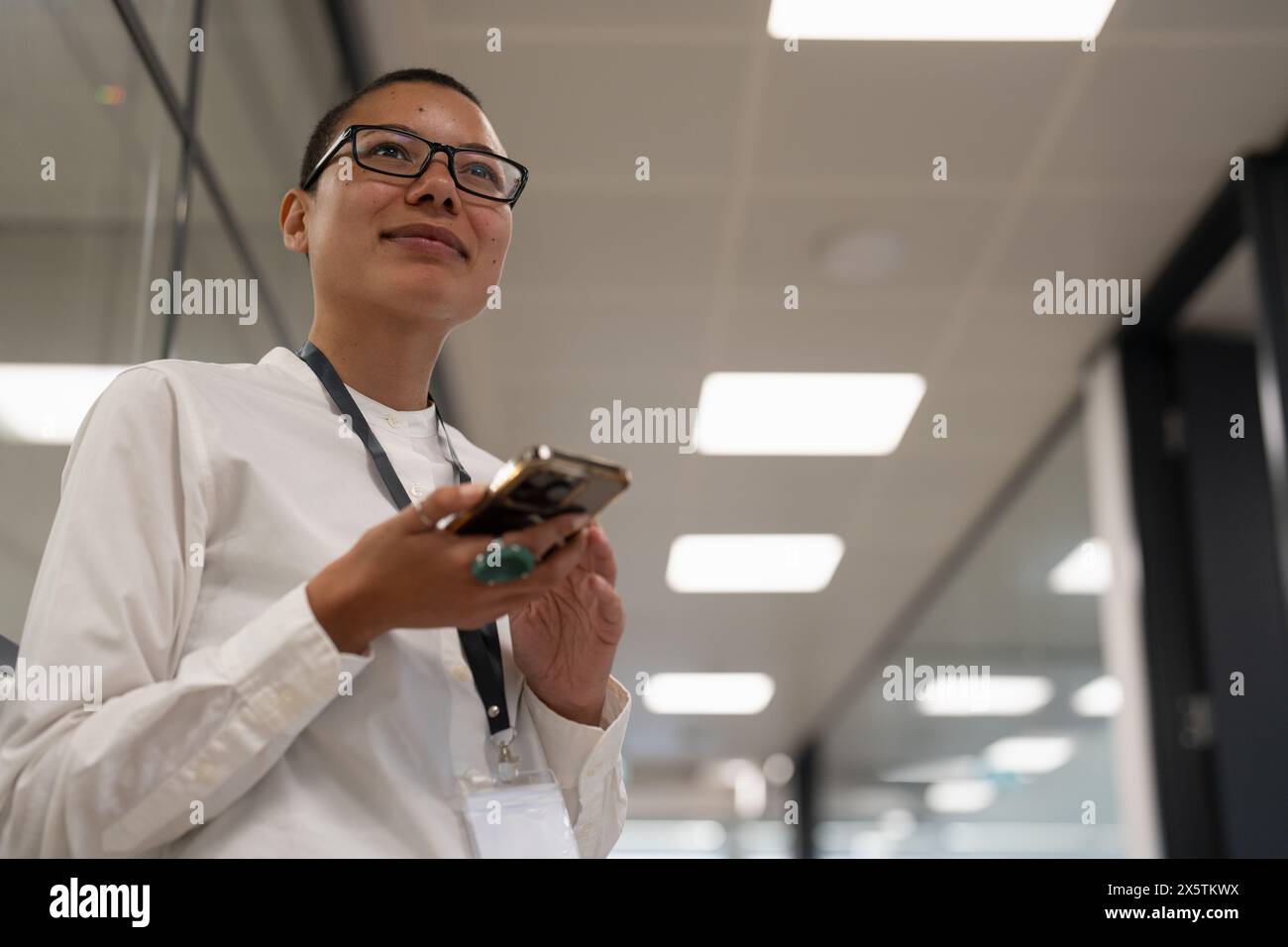 Nicht binärer Büroangestellter, der auf dem Flur steht Stockfoto