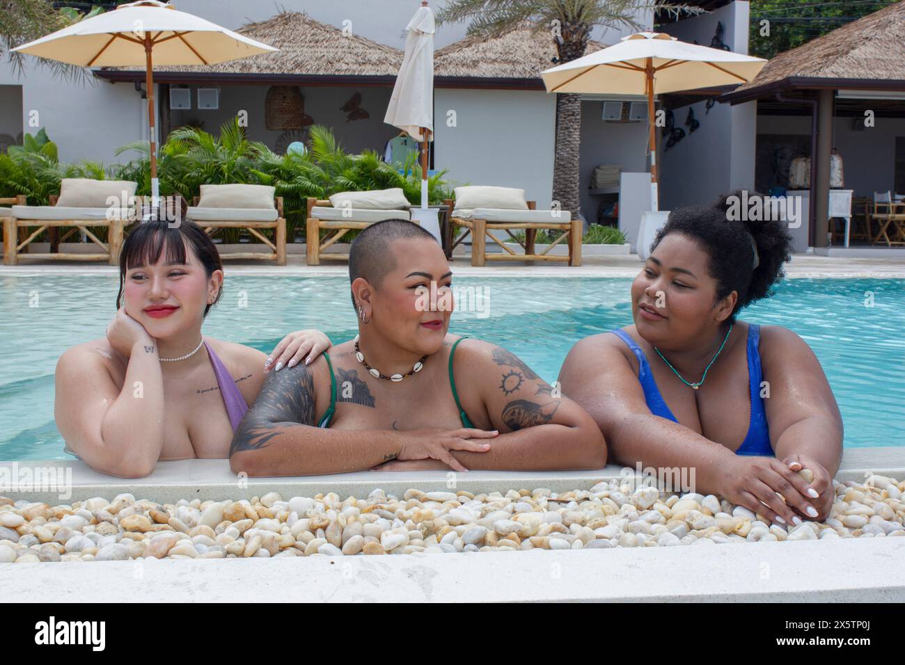 Gruppe von fröhlichen Frauen, die sich am Pool entspannen Stockfoto